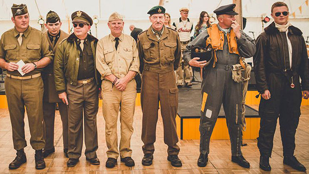 Group of people wearing vintage military and aviation costumes at the Goodwood Revival event.