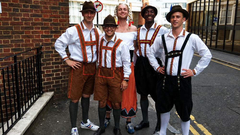 Group of people wearing traditional Bavarian costumes at an Oktoberfest event in London.